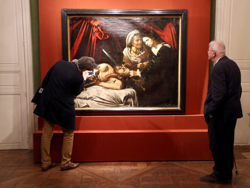 PHOTO: Visitors looks at a painting entitled Judith Beheading Holofernes during its presentation in Paris, April 12, 2016.