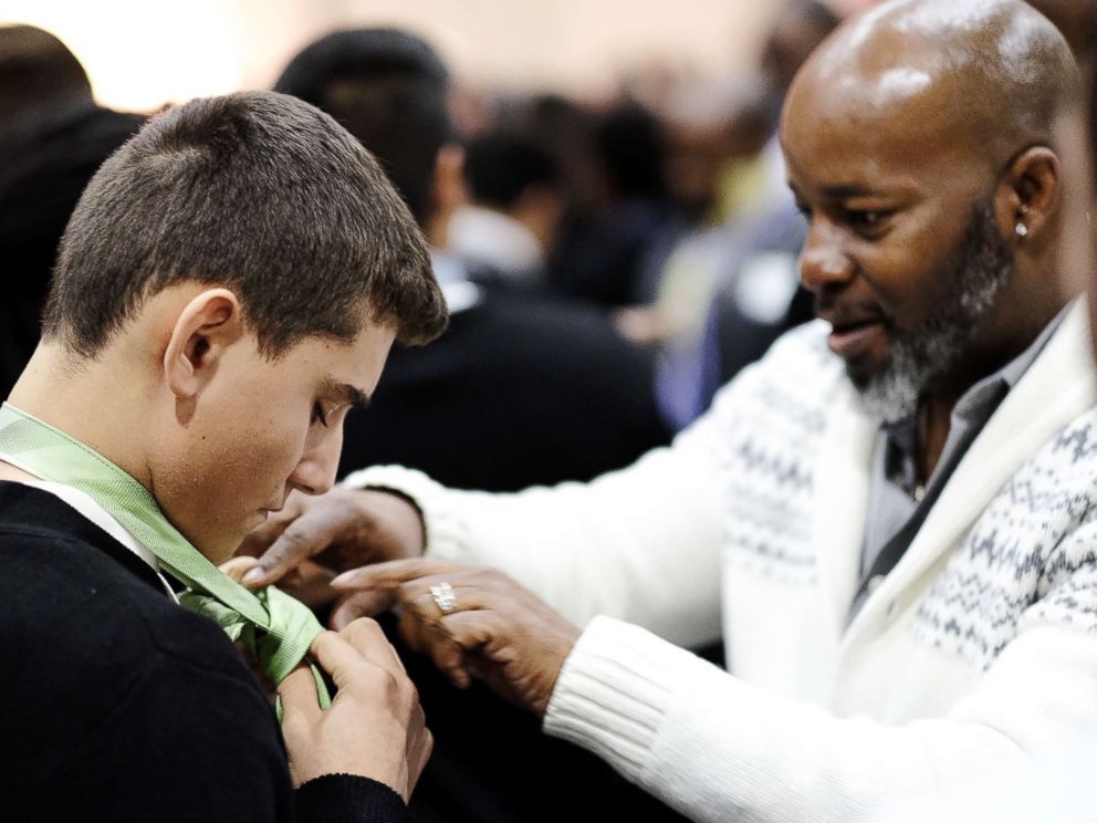 PHOTO: A mentor teaches a student to tie a tie at Billy Earl Dade Middle Schools Breakfast with Dads event on Dec. 14, 2017.
