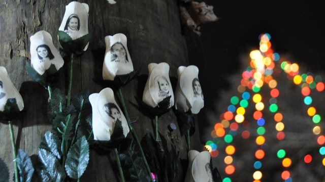 PHOTO: Roses printed with the faces of the victims are placed at a memorial around a Christmas tree in the center of Sandy Hook, Conn.