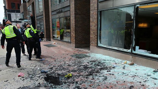 PHOTO: Boston Police look at blown out windows at the scene near the finish line of the Boston Marathon, April 15, 2013.