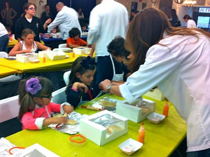 PHOTO: Chef Karen assists children at the Cookie Baking and Decorating event.