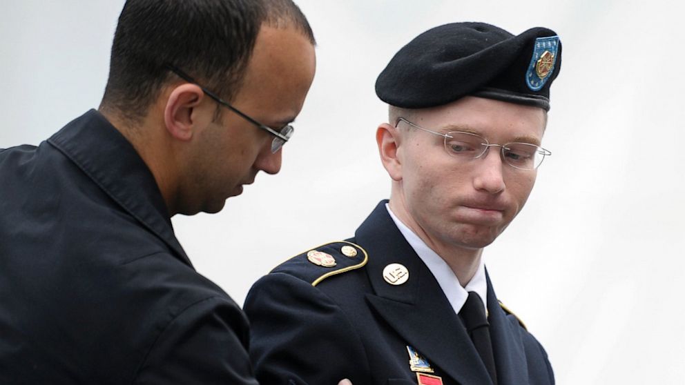 Army Pfc. Bradley Manning, right, is escorted into a courthouse at Fort Mead, Md., for the fourth day of his court martial, June 10, 2013. 