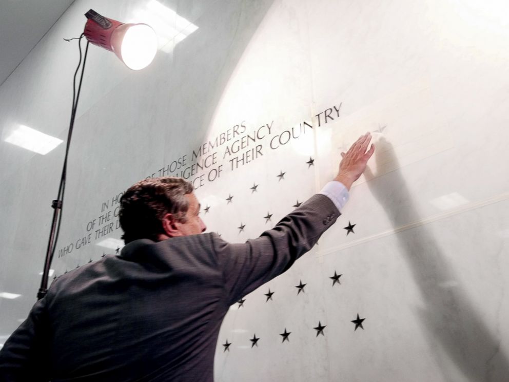 PHOTO: Former Director of the Central Intelligence Agency George Tenet reaches out to touch a five-pointed star freshly carved into the marble-faced lobby wall of CIA headquarters in Langley, Va., May 23, 2002.