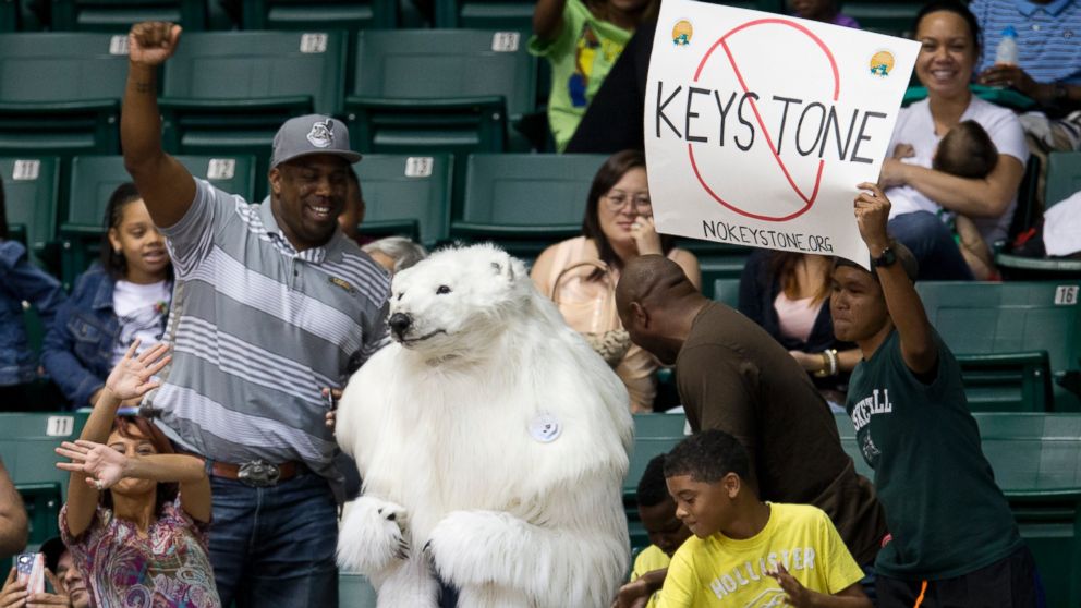 PHOTO: A person dressed as a polar bear and others demonstrate against the Keystone Pipeline as President Barack Obama attends the Oregon State University versus University of Akron college basketball game in Honolulu, Dec. 22, 2013.