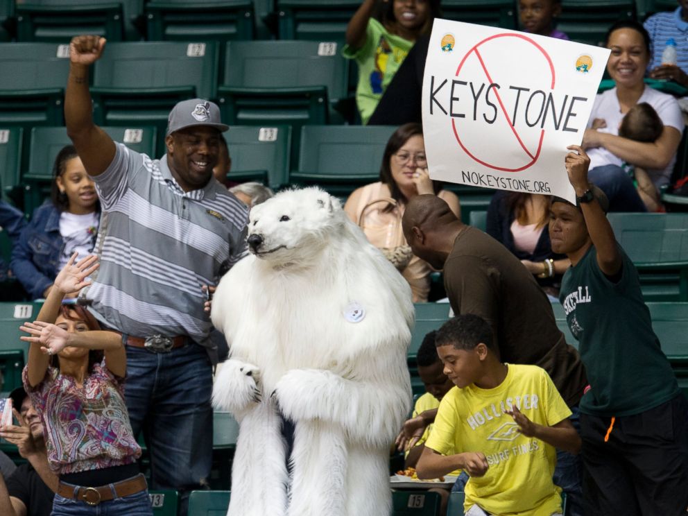 PHOTO: A person dressed as a polar bear and others demonstrate against the Keystone Pipeline as President Barack Obama attends the Oregon State University versus University of Akron college basketball game in Honolulu, Dec. 22, 2013.