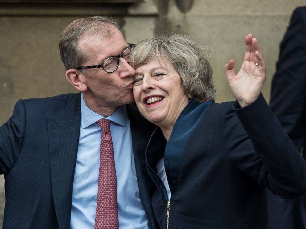 PHOTO: Theresa May receives a kiss from her husband Philip John May after speaking to members of the media at The St Stephens entrance to the Palace of Westminster in London, July 11, 2016.