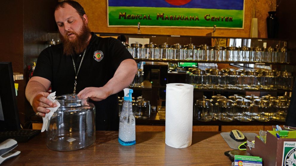PHOTO: Kurt Britz cleans jars that will hold recreational marijuana at 3D Cannabis Center in Denver, Dec. 30 2013.