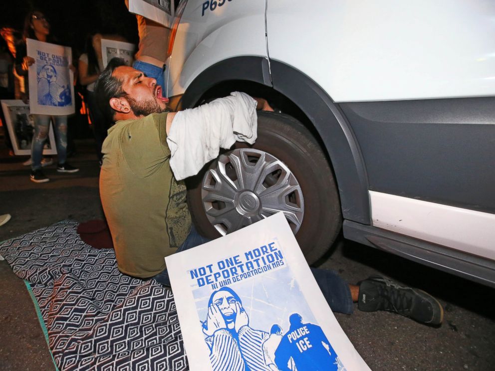 PHOTO: A protester locks himself to the van carrying Guadalupe Garcia de Rayos outside the ICE office in Phoenix, Ariz., Feb. 8, 2017.