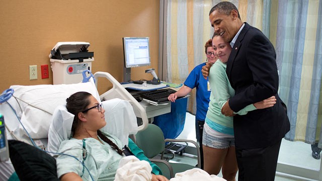 PHOTO: President Barack Obama hugs Stephanie Davies, who helped keep her friend, Allie Young, left, alive after she was shot during the movie theatre shootings in Aurora, Colo., July 22, 2012.