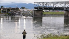 PHOTO: A person looks from the south bank of the Skagit River across to the collapsed portion of the Interstate 5 bridge, May 24, 2013, in Mount Vernon, Wash.