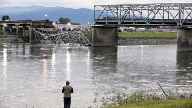 PHOTO: A person looks from the south bank of the Skagit River across to the collapsed portion of the Interstate 5 bridge, May 24, 2013, in Mount Vernon, Wash.