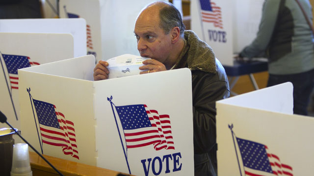 PHOTO: Seth Blank seals an envelope containing his absentee ballot for the Nov. 6th election at the town hall in Cape Elizabeth, Maine, Thursday, Oct. 25, 2012.