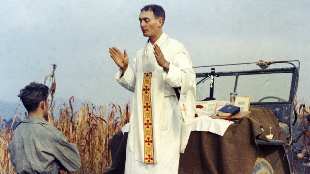 PHOTO: Father Emil Kapaun celebrates Mass using the hood of his jeep as an altar, as his assistant, Patrick J. Schuler, kneels in prayer in Korea on Oct. 7, 1950, less than a month before Kapaun was taken prisoner where he died in a prisoner of war camp o