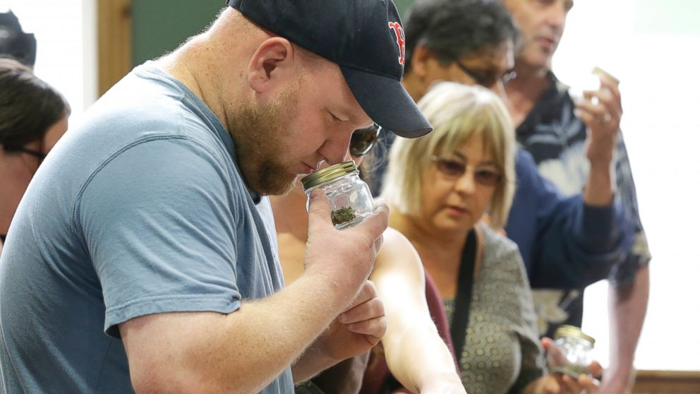 PHOTO: A customer sniffs a strain of recreational marijuana at Top Shelf Cannabis, Tuesday, July 8, 2014, in Bellingham, Wash., during the first half-hour of legal sales in the states.