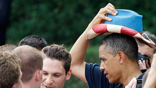 PHOTO: President Barack Obama puts on a red, white, and blue hat, while visiting with service members during the Independence Day celebration in Washington, July 4, 2012.