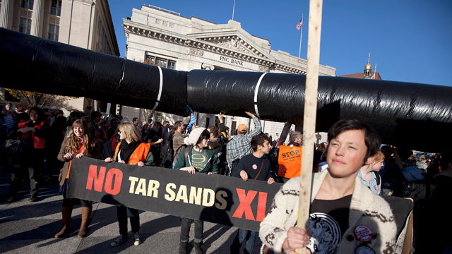 PHOTO: Demonstrators march with a replica of a pipeline during a protest to demand a stop to the Keystone XL tar sands oil pipeline outside the White House, in this Nov. 6, 2011 file photo, in Washington.