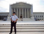 A police officer keeps watch outside the Supreme Court in Washington, June 17, 2013.