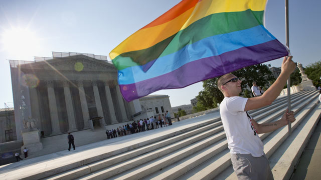 PHOTO: Vin Testa of Washington waves a rainbow flag in support of gay rights outside the Supreme Court in Washington, June 25, 2013, as key decisions are expected to be announced.