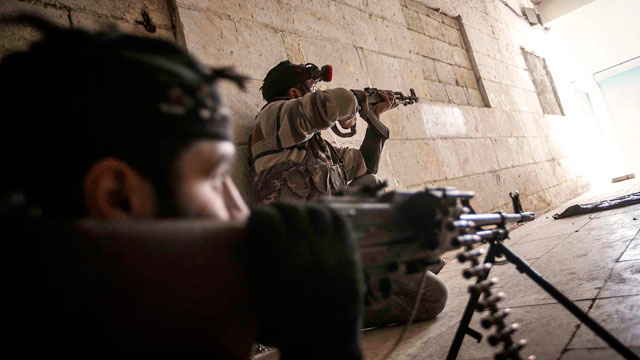 PHOTO: Free Syrian Army fighters aim their weapons at the entrance of a building during heavy clashes with government forces in Aleppo, Syria, Dec. 5, 2012.
