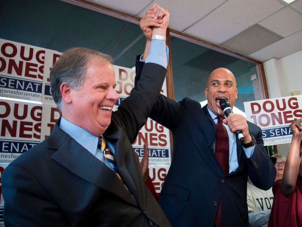 PHOTO: Senator Cory Booker raises the arm of Democratic Senatorial candidate Doug Jones while speaking at Jones campaign headquarters in Birmingham, Alabama, Dec. 10, 2017.