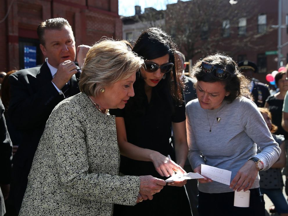 PHOTO: Hillary Clinton (L) talks with aides Huma Abedin (C) and Connolly Keigher before speaking at a neighborhood block party, April 17, 2016, in Brooklyn, New York.