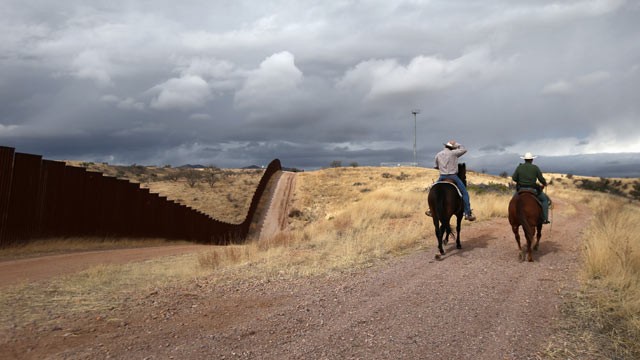 PHOTO: U.S. Border Patrol ranch liaison John "Cody" Jackson (R) rides with cattle rancher Dan Bell on Bells ZZ Cattle Ranch along the U.S.-Mexico border fence on March 8, 2013 in Nogales, Ariz.
