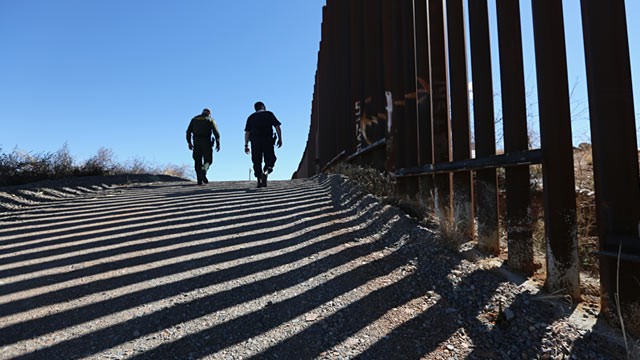 PHOTO: U.S. Customs and Border Protection personnel walk along a section of a recently constructed fence at the U.S.-Mexico border, Feb. 26, 2013, in Nogales, Ariz.