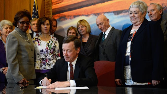 PHOTO: Colorado Governor John Hickenlooper signs three gun control measures in his office at the state capitol, March, 20, 2013.