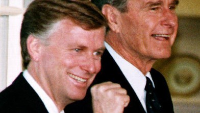 PHOTO: U.S. Vice President Dan Quayle reacts as he and President George Bush walk into the White House in Washington, DC after a welcome home rally 14 October, 1992.
