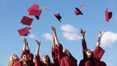 PHOTO: College grads throw their caps into the air after graduation ceremony.