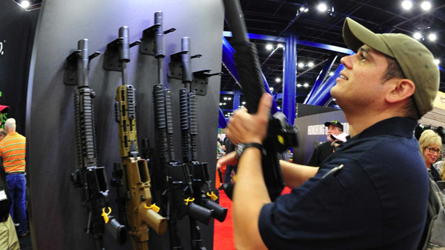 PHOTO: A convention goers picks up a weapon equipped with a silencer during the 142nd annual National Rifle Association (NRA)Convention at the George R. Brown Convention Center May 4, 2013 in Houston, Texas.