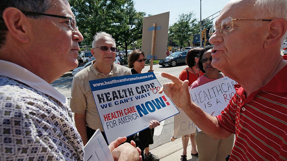 PHOTO: Opponents argue over heath insurance reform outside town hall