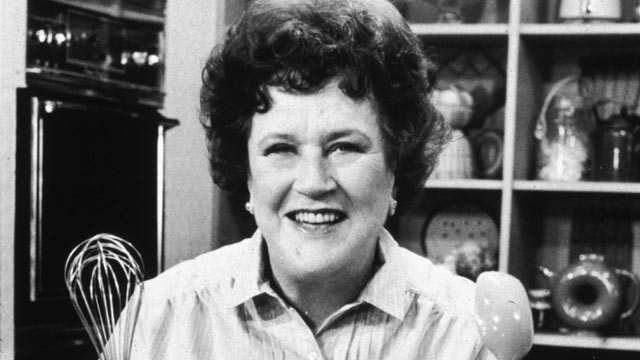 PHOTO: American chef Julia Child stands in front of a countertop, holding a whisk and a ladle, on the set of her television series, "The French Chef".