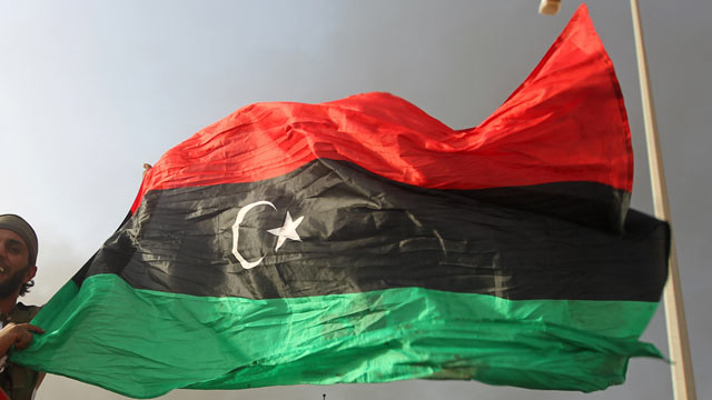 PHOTO: A Libyan National Transitional Council (NTC) fighter waves the Libyan revolution flag in Sirte after fierce fighting against loyalist troops, Oct. 9, 2011.