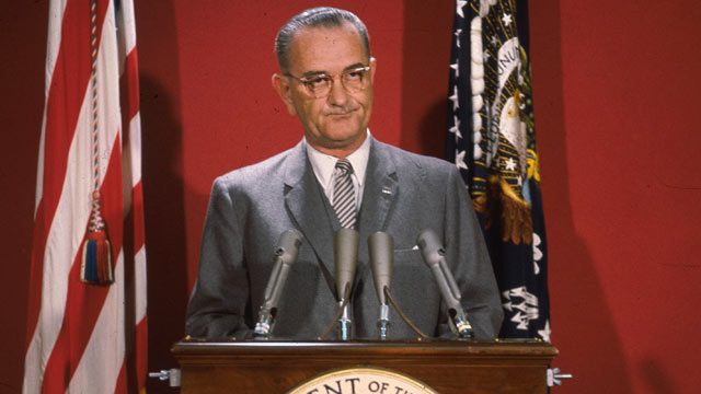 PHOTO: American statesman Lyndon Baines Johnson, the 36th President of the United States of America, making an address at a podium flanked by two flags, around 1965.