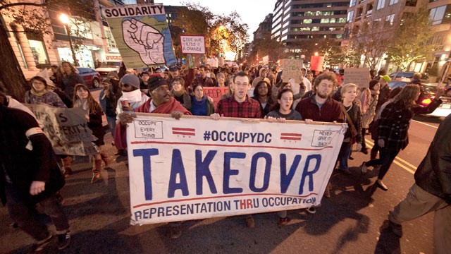 PHOTO: Protesters from Occupy DC march past the Washington Convention Center during a demonstration against the billionaire conservative donor Koch brothers and Americans for Prosperity, Washington, DC, Nov. 4, 2011.