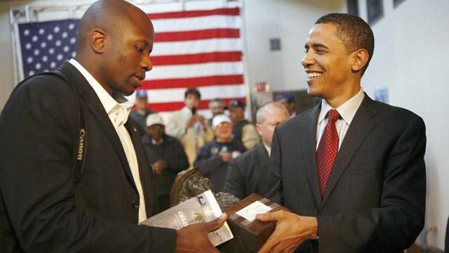 PHOTO: Presidential candidate Illinois Senator Barack Obama, hands over a statue to his assistant Reggie Love during a town hall meeting with veterans at the American GI Forum in San Antonio, Texas, March 3, 2008.