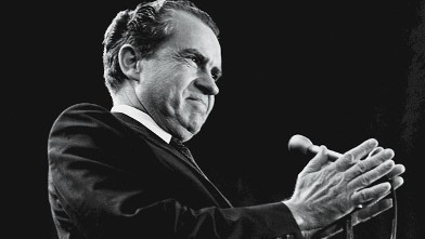 PHOTO: American President Richard Nixon holds his hands together before him around a microphone as he grins during a campaign rally at Madison Square Garden, New York, Oct. 31, 1968.