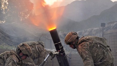 PHOTO: US army soldiers from Bravo company 2nd Batallion 27th Infantry Regiment fire 120 mm mortar rounds towards insurgent positions at Outpost Monti in Kunar province, Sept. 17, 2011.