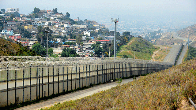 A fence runs along the US-Mexico border between the Otay Mesa and San Ysidro ports of entry in and near San Diego, Calif., across from Tijuana, Mexico, April 4, 2013.