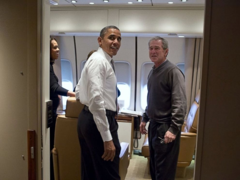 President Barack Obama jokes with former President George W. Bush shortly after boarding Air Force One for the trip to South Africa, Dec. 9, 2013.