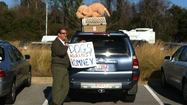 PHOTO: An unidentified man holds up a sign reading, "Dogs against Romney" in this handout photo.