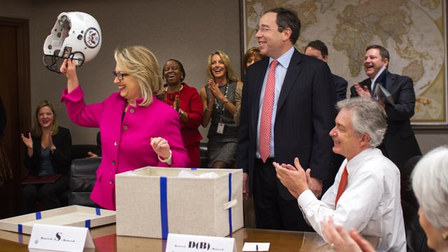 PHOTO: Hillary Clinton receives a football helmet in a State Department meeting from Deputy Secretary Tom Nides, Jan. 7, 2012.