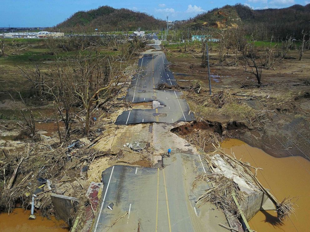 PHOTO: A man rides his bicycle through a damaged road in Toa Alta, west of San Juan, Puerto Rico, Sept. 24, 2017, following the passage of Hurricane Maria.