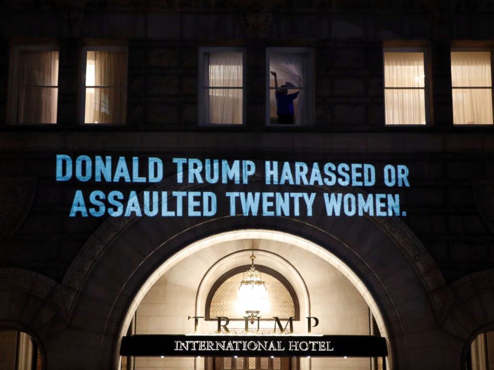 PHOTO: A person waves from a window as UltraViolet, a national womens group, projects a message on the 12th Street side of the Trump International Hotel before President Donald Trump gives his State of the Union Address, Jan. 30, 2018, in Washington.