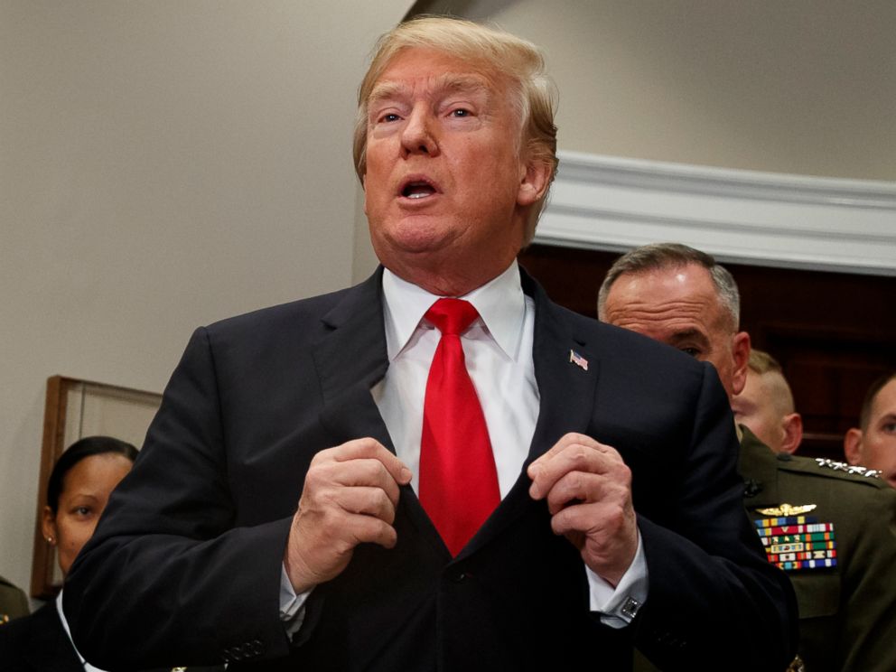 PHOTO: President Donald Trump adjusts his suit jacket after signing the National Defense Authorization Act for Fiscal Year 2018 bill, in the Roosevelt Room of the White House, Dec. 12, 2017.