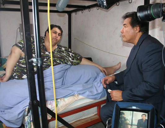 Pic: ABC's John Quinones at Manuel Uribe's bedside in late 2006, when he was several hundred pounds heavier than he is today.
