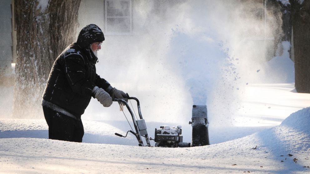 PHOTO: A resident cleans inches of new-fallen snow from his driveway in St. Cloud, Minn., Jan. 18, 2014.