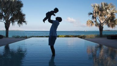 PHOTO: JAY Z stands in an infinity pool as he holds his daughter Blue Ivy Carter