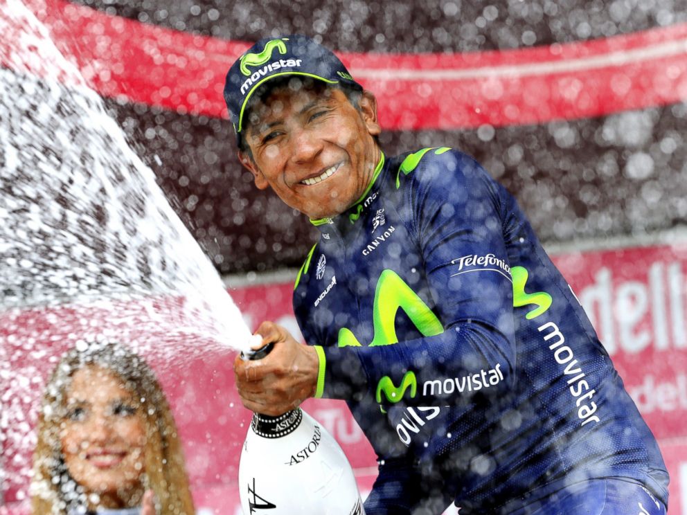 PHOTO: Colombias Nairo Quintana sprays champagne on the podium as he celebrates winning the 16th stage of the 97th Giro dItalia (Tour of Italy) cycling race, 139 km from Ponte di Legno to Val Martello, on May 27, 2014 in Val Martello.